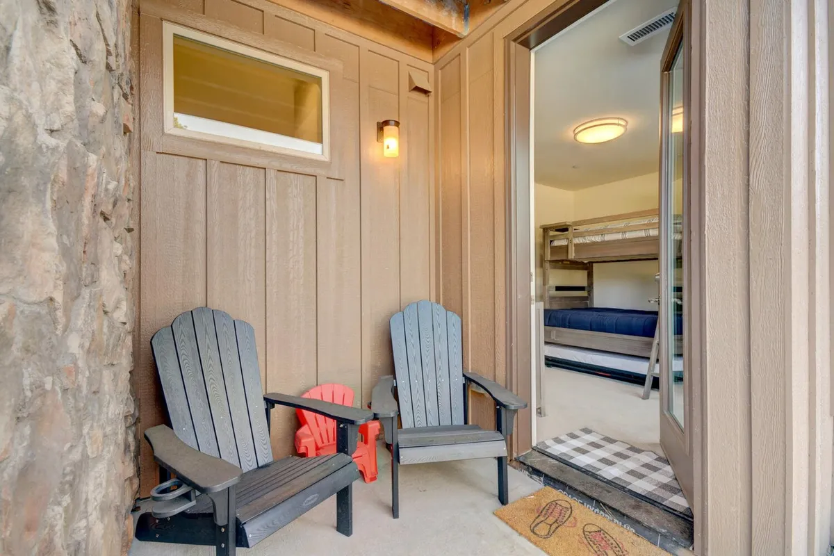 A cozy exterior seating area with Adirondack chairs placed near an open door, set against a textured wall. The space is ideal for relaxing, enjoying a morning coffee, or unwinding after an adventurous day.